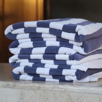 Folded striped towels on a marble shelf